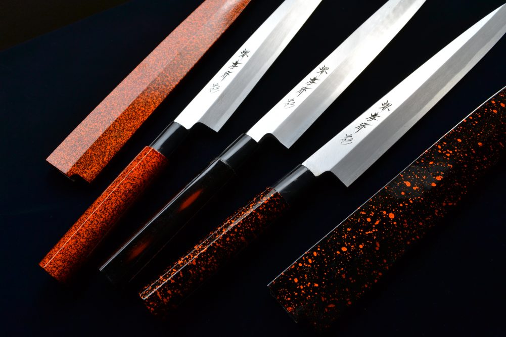 Eneggede Sakai Takayuki-kniver med lakkerte skaft i rødt og svart. Foto: Aoki Hamono