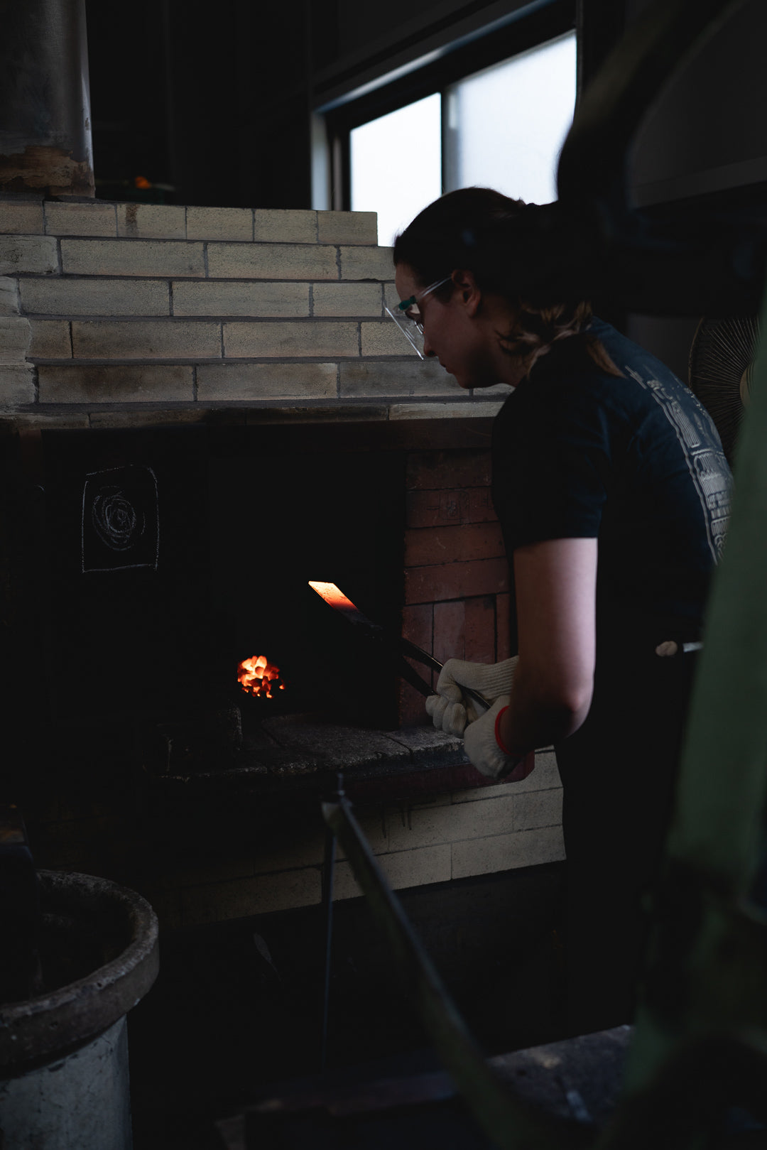 One of us at the forge, with a glowing blank on its way into the heat