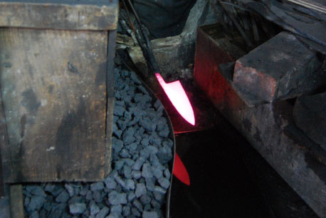 Red-hot blade in the charcoal before hardening.